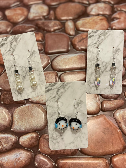 Set of earrings on marble card with pebbly background