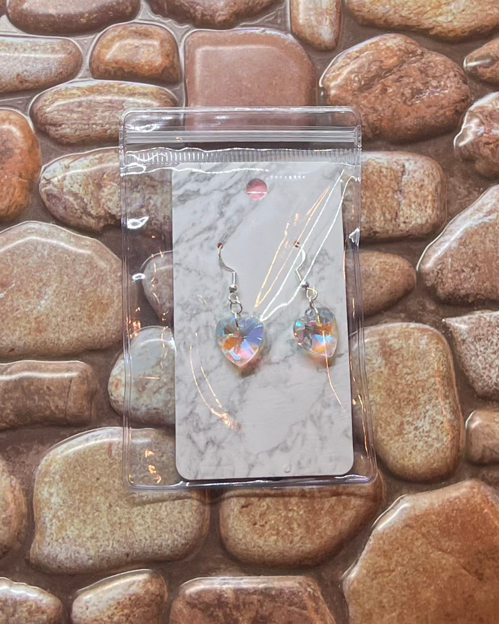 Earring set on a marble card with a stone background